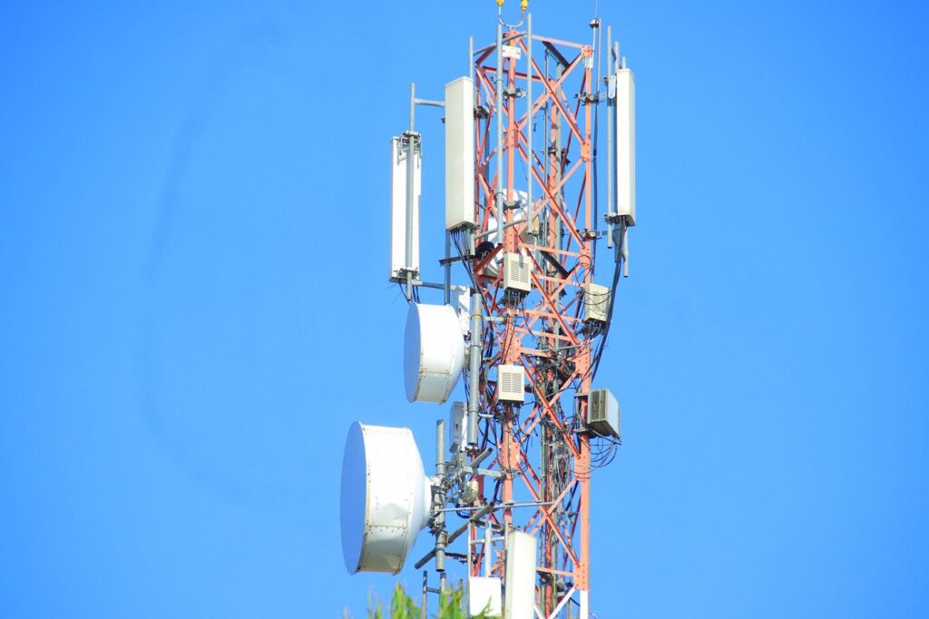 A mobile phone tower rising over a rural landscape