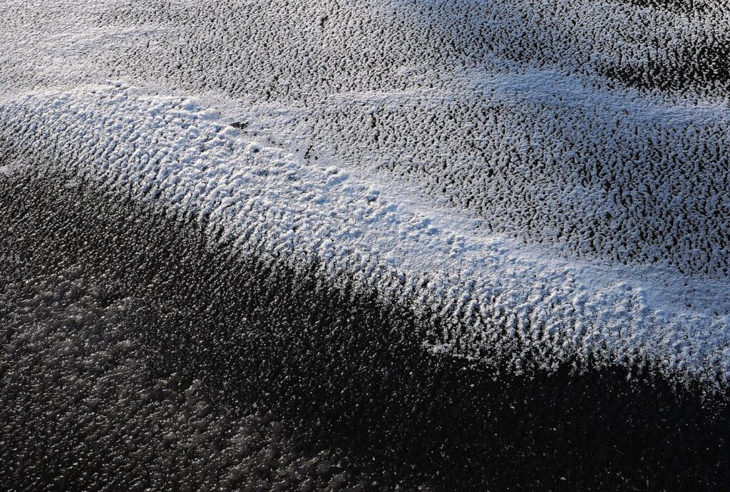 Mountain Communities Monitor Growing Glacier Lakes A glacial lake beneath ice-covered peaks